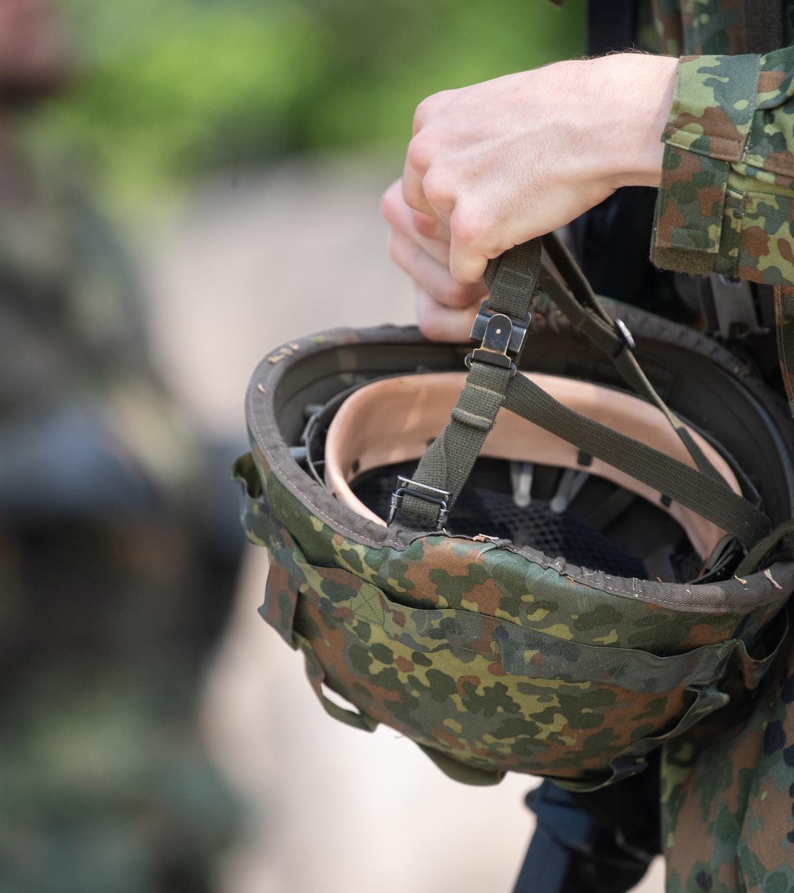 Bayern, Hammelburg: Ein Reservist in Ausbildung hält während eines Ausbildungsmoduls des Projektes "Ungediente für die Reserve" des Landeskommandos Hessen auf dem Truppenübungsplatz Hammelburg seinen Helm in der Hand.