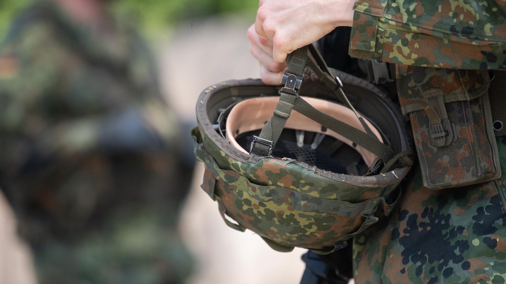 Bayern, Hammelburg: Ein Reservist in Ausbildung hält während eines Ausbildungsmoduls des Projektes "Ungediente für die Reserve" des Landeskommandos Hessen auf dem Truppenübungsplatz Hammelburg seinen Helm in der Hand.