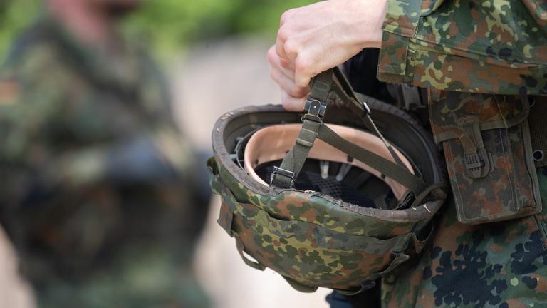 Bayern, Hammelburg: Ein Reservist in Ausbildung hält während eines Ausbildungsmoduls des Projektes "Ungediente für die Reserve" des Landeskommandos Hessen auf dem Truppenübungsplatz Hammelburg seinen Helm in der Hand.