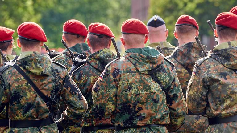 Eine Gruppe von Soldaten der Deutschen Bundeswehr in Tarnuniformen stehen in Formation