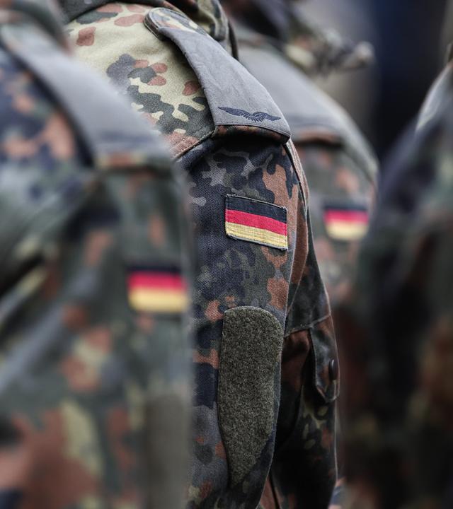 Soldaten tragen Deutschlandflaggen auf ihrer Uniform.