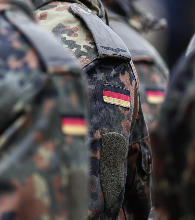 Symbolbild: Soldaten tragen Deutschlandflaggen auf ihrer Uniform.