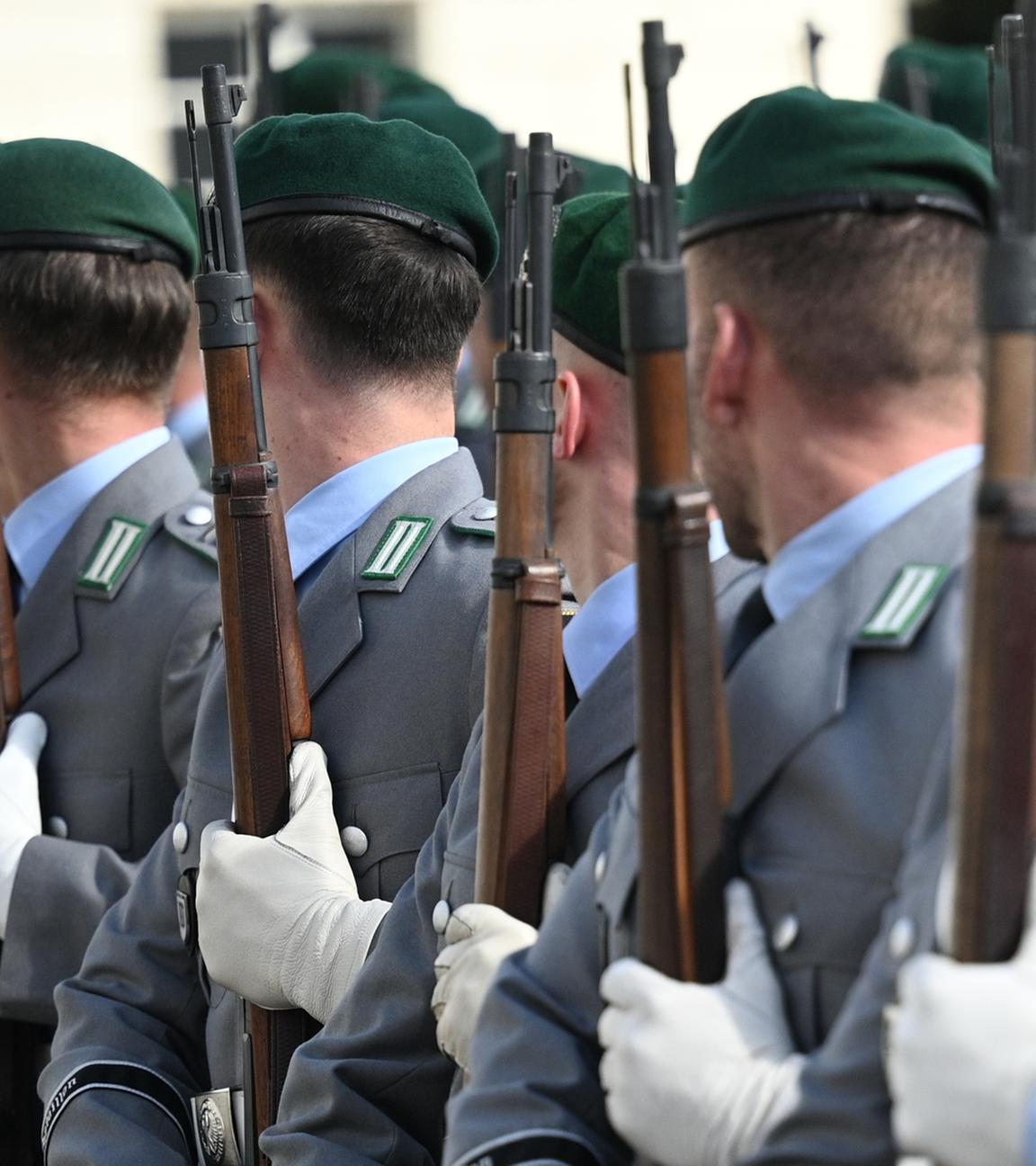 Soldatinnen und Soldaten der Bundeswehr stehen für eine Zeremonie mit Gewehren in einer Reihe