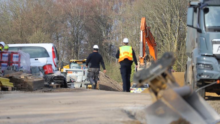 Nordrhein-Westfalen, Bergisch Gladbach: Ein Zollbeamter läuft über eine Baustelle.