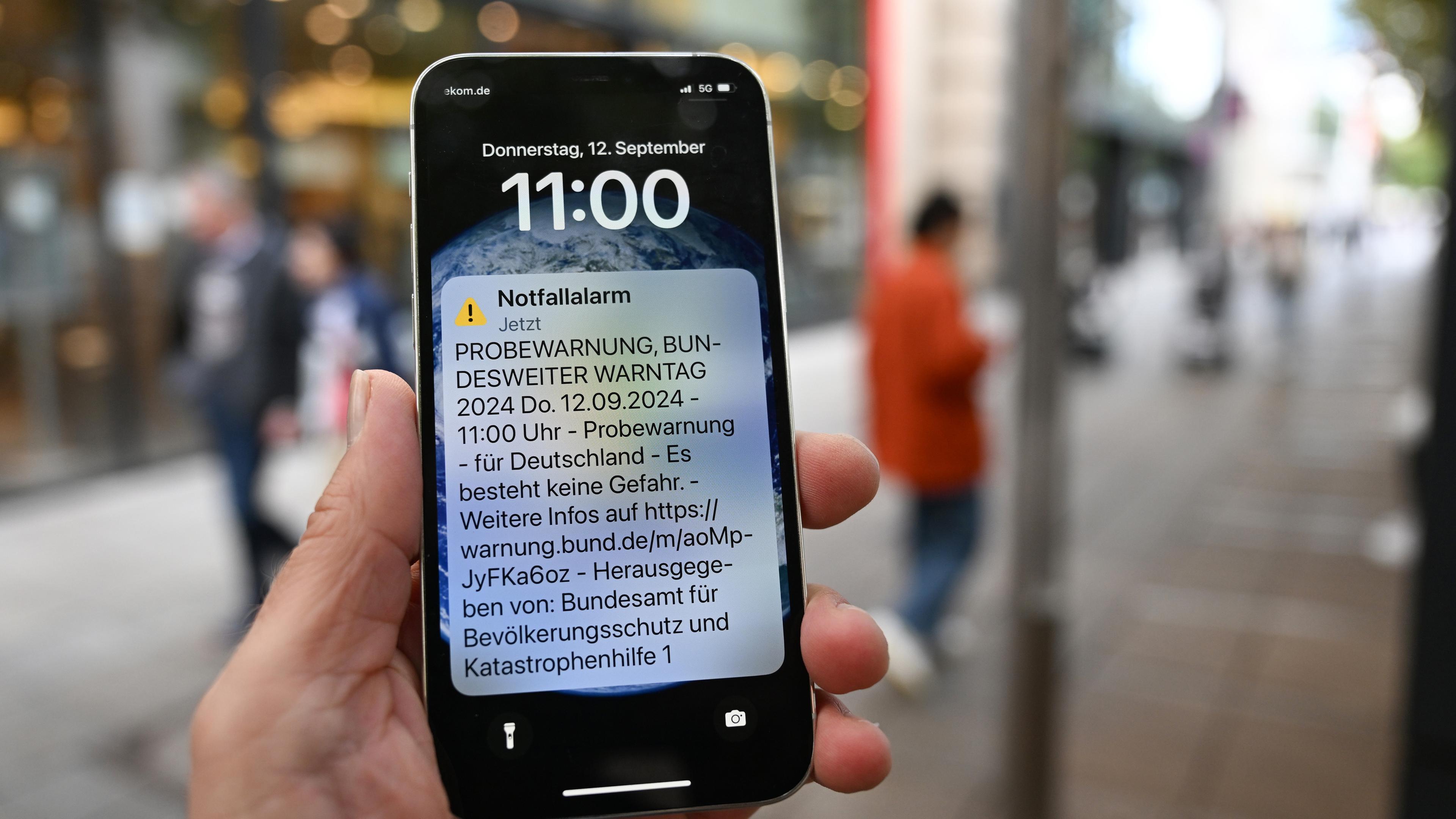 Symbolbild:  Eine Probewarnung ist am Warntag in der Innenstadt auf einem Smartphone angezeigt. 