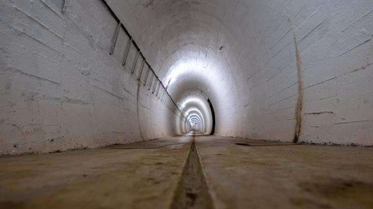 Ein Hohlgang eines ehemaligen Bunkers, dessen Wände weiß sind.