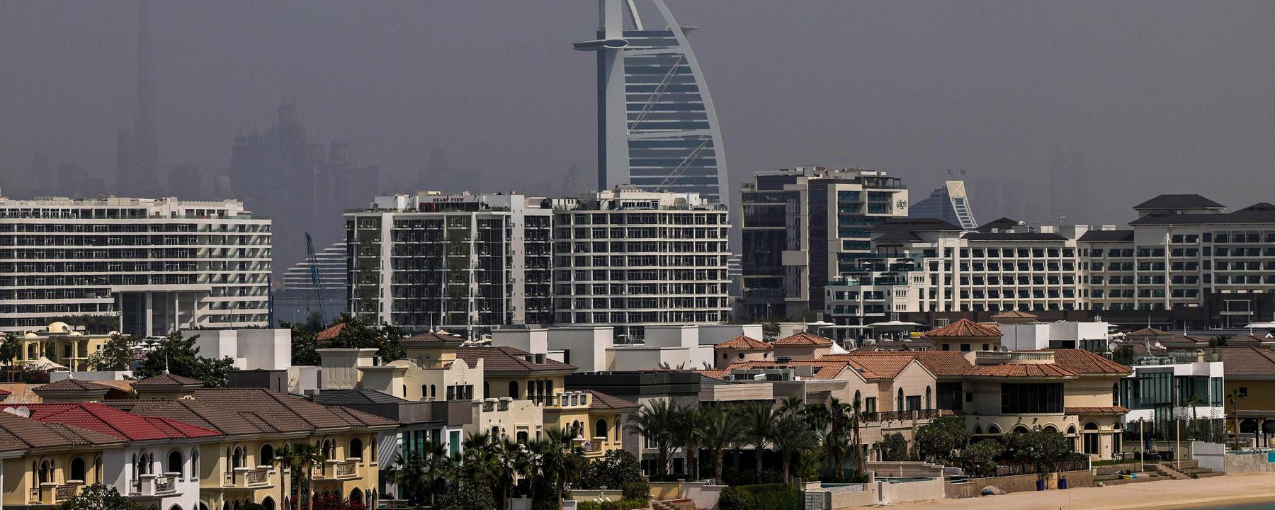 Zwei Personen spazieren am 02.032026 an einem menschenleeren Strand auf Palm Jumeirah in Dubai entlang