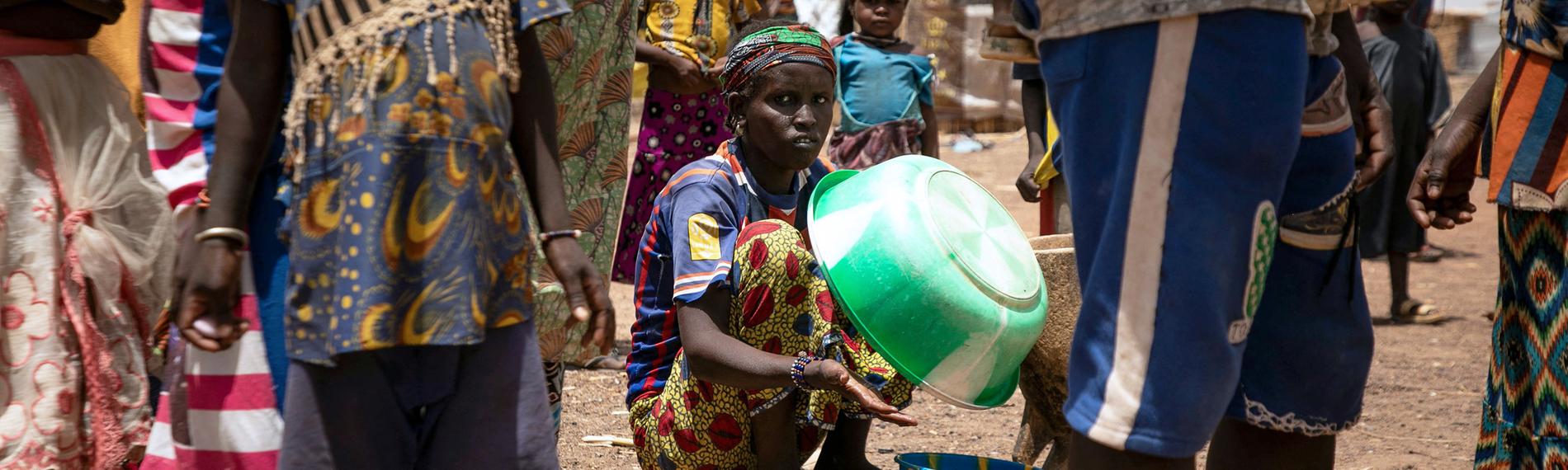 Eine vertriebene Frau hält eine Plastikschüssel im Flüchtlingslager Torodi in Dori, Burkina Faso