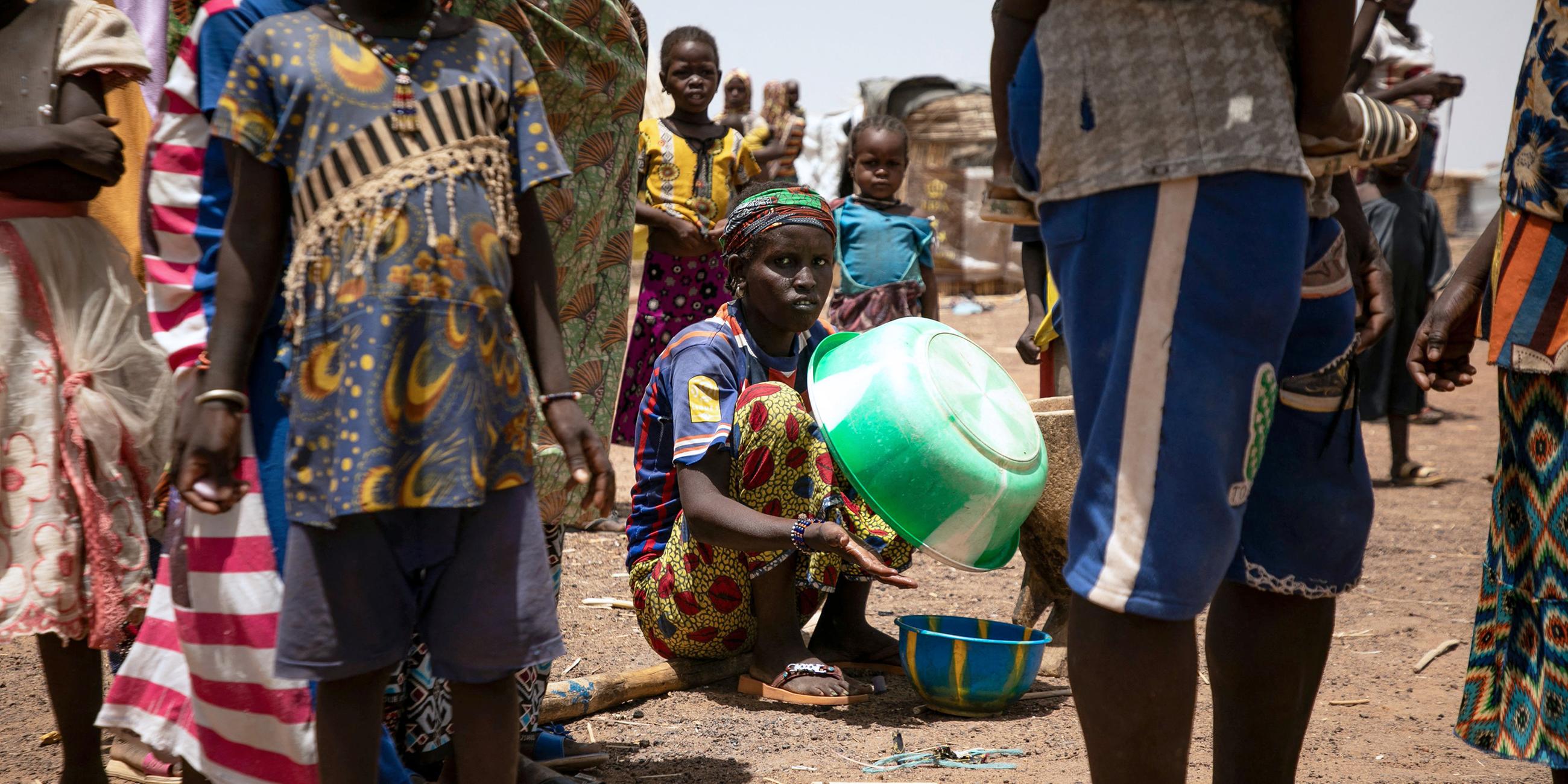 Eine vertriebene Frau hält eine Plastikschüssel im Flüchtlingslager Torodi in Dori, Burkina Faso