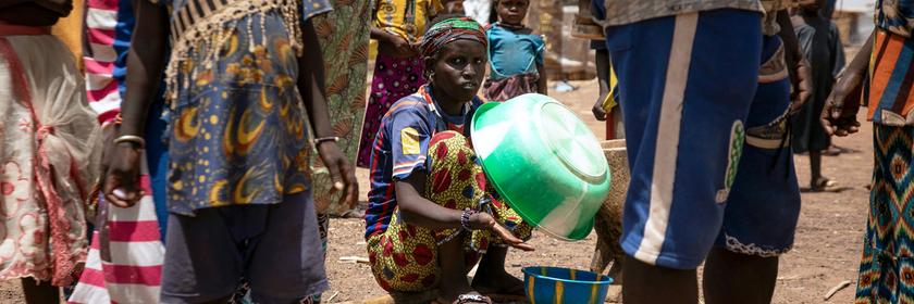 Eine vertriebene Frau hält eine Plastikschüssel im Flüchtlingslager Torodi in Dori, Burkina Faso