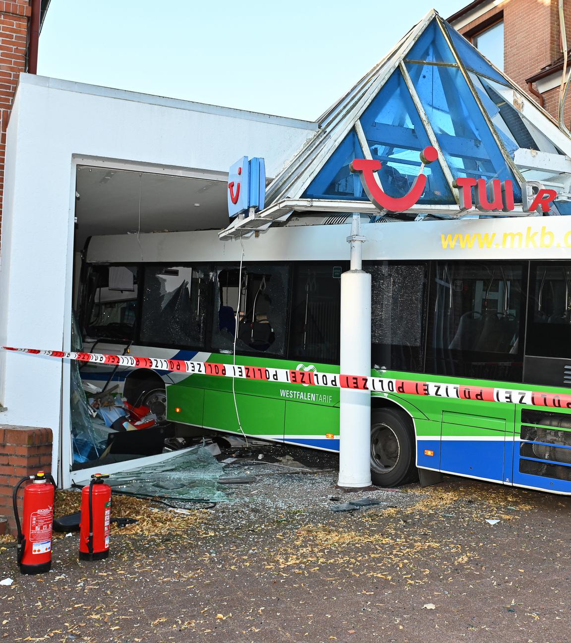 Linienbus kracht in Reisebüro