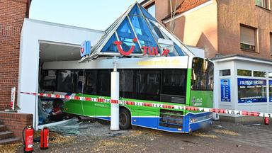 Linienbus kracht in Reisebüro