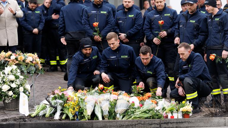 Feuerwehrleute stehen an der Stelle, an der am Vorabend ein Linienbus ausgebrannt ist. Bei dem Inferno starben sechs Menschen, fünf Personen wurden verletzt.