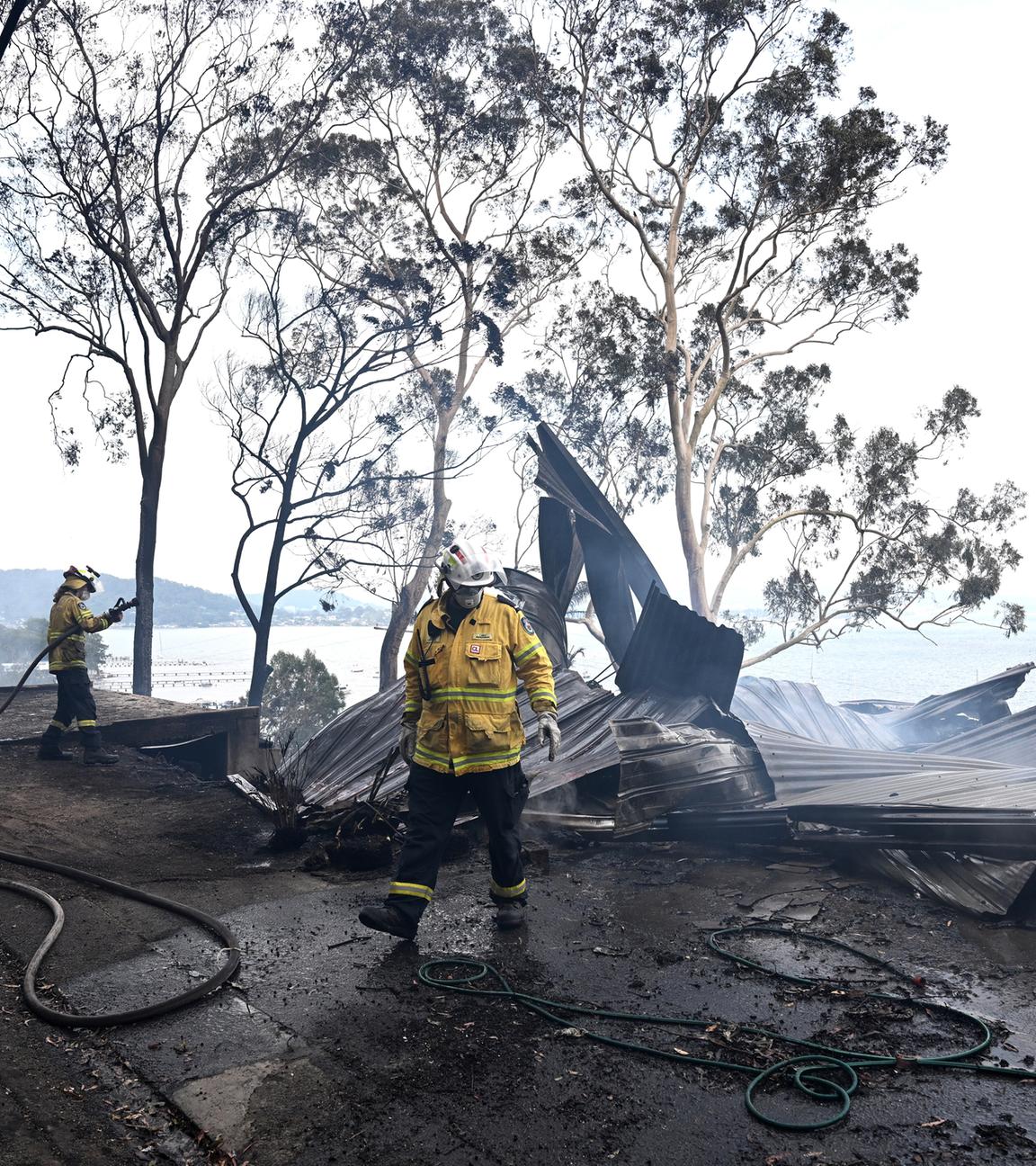 Feuerwehrleute bekämpfen einen Buschbrand, der sich am 06.12.2025 in der Region Koolewong an der Central Coast in New South Wales (NSW), Australien, ausbreitet. 