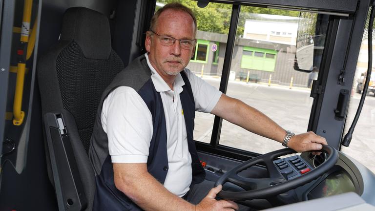 Busfahrer Jörg Schönebeck hinter dem Steuer des Busses auf dem Omnibus-Betriebshof Cicerostraße.