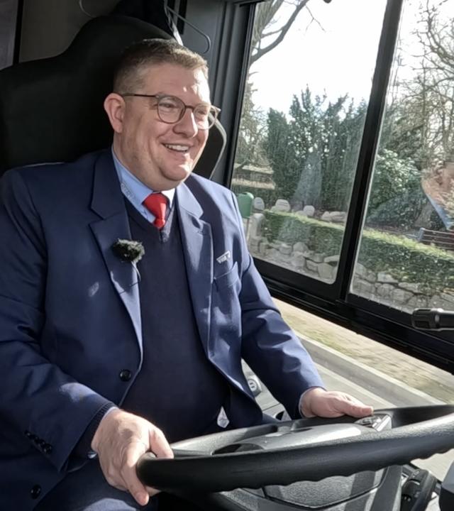 Zahnarzt Dr. Schmidt fährt fröhlich einen Bus