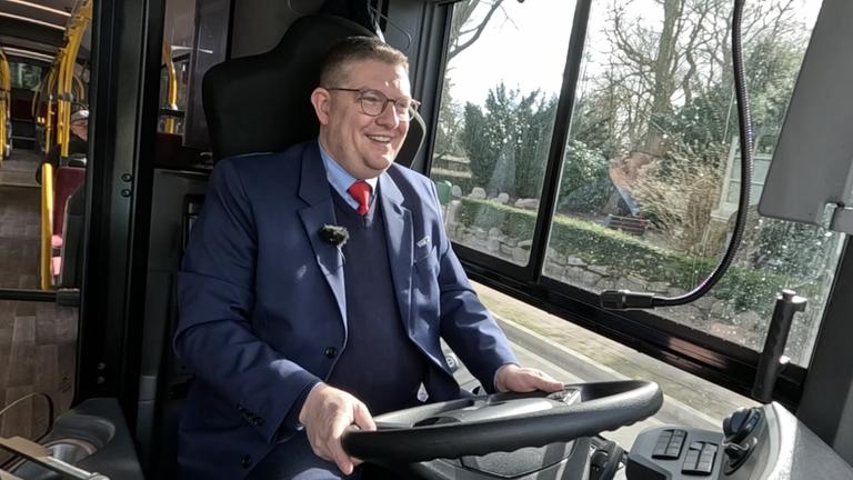 Zahnarzt Dr. Schmidt fährt fröhlich einen Bus