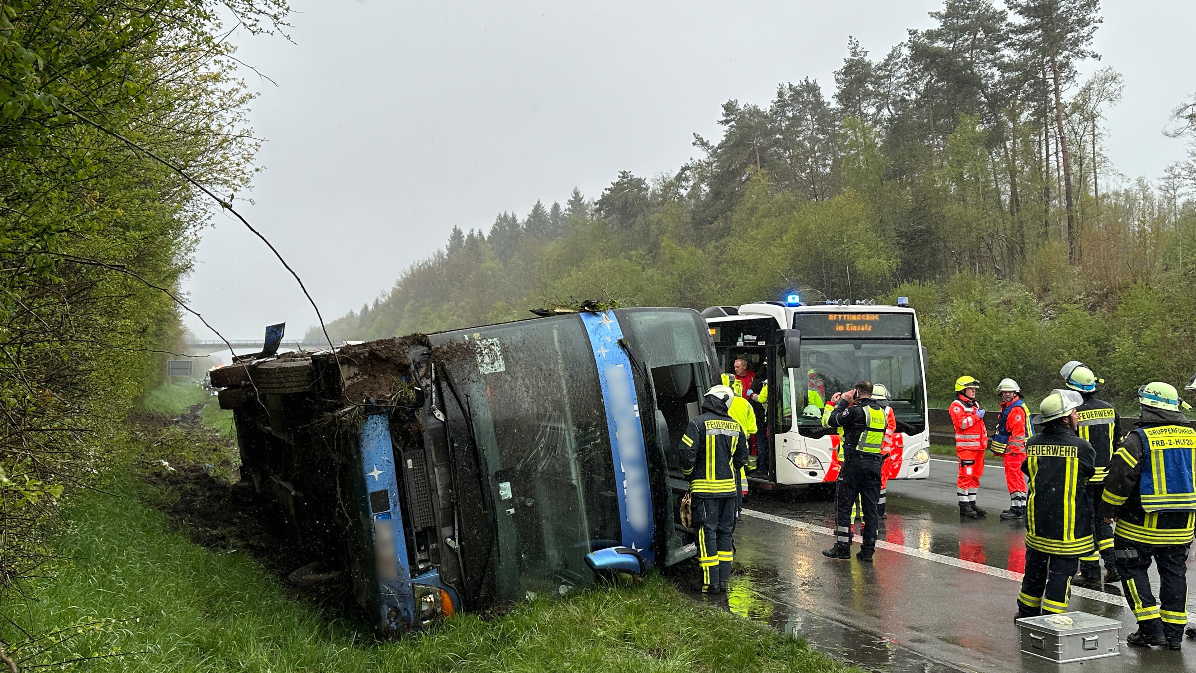 Ein Bus liegt umgefallen am Straßenrand. 