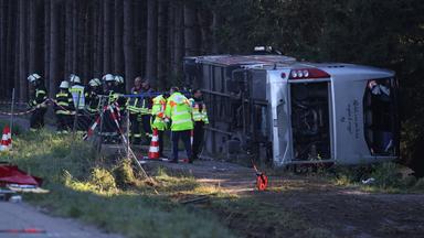 Bayern, Buchloe: Polizei, Rettungsdienste und Feuerwehr stehen an der Unfallstelle bei Buchloe-Ost, wo ein Reisebus auf der A96 umgekippt ist.