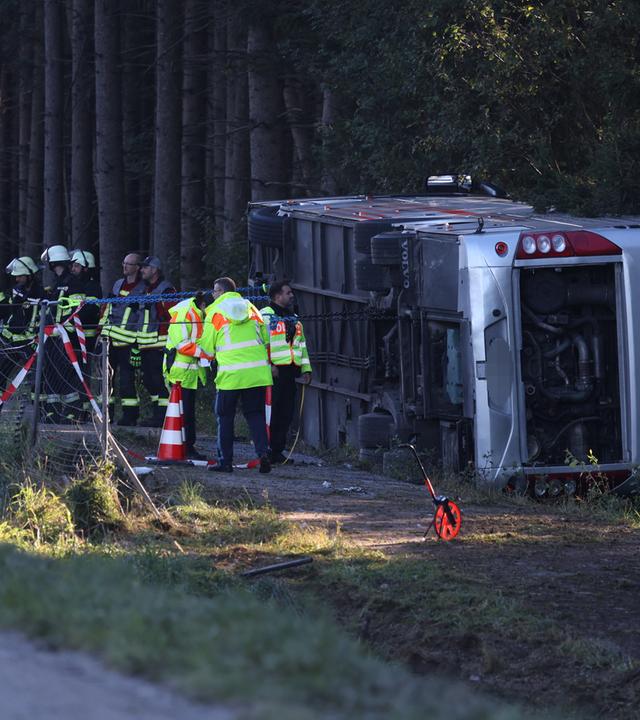 Bayern, Buchloe: Polizei, Rettungsdienste und Feuerwehr stehen an der Unfallstelle bei Buchloe-Ost, wo ein Reisebus auf der A96 umgekippt ist.