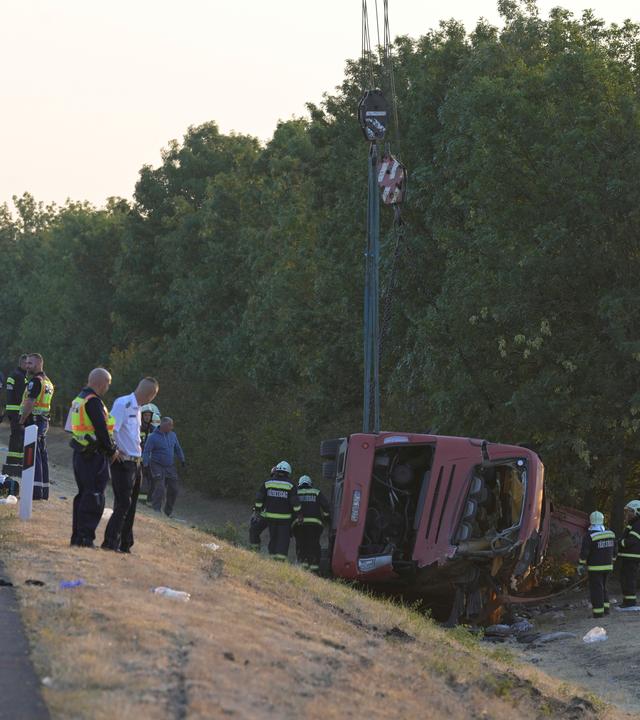 Rettungskräfte sind vor Ort, nachdem ein Personenbus von der Straße abgekommen und in einen Graben gestürzt war.