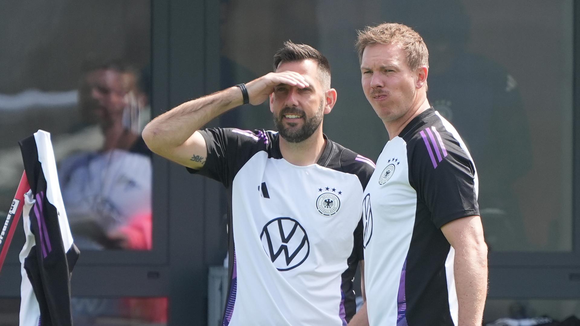 Bundestrainer Julian Nagelsmann (rechts) und Standard-Trainer Mads Buttgereit schauen den deutschen Spielern beim Traing in Herzogenaurach zu.