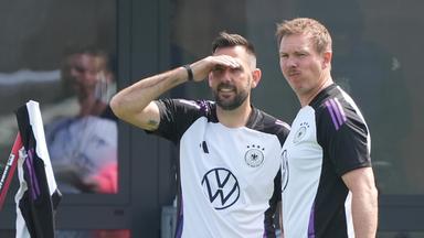 Bundestrainer Julian Nagelsmann (rechts) und Standard-Trainer Mads Buttgereit schauen den deutschen Spielern beim Traing in Herzogenaurach zu.