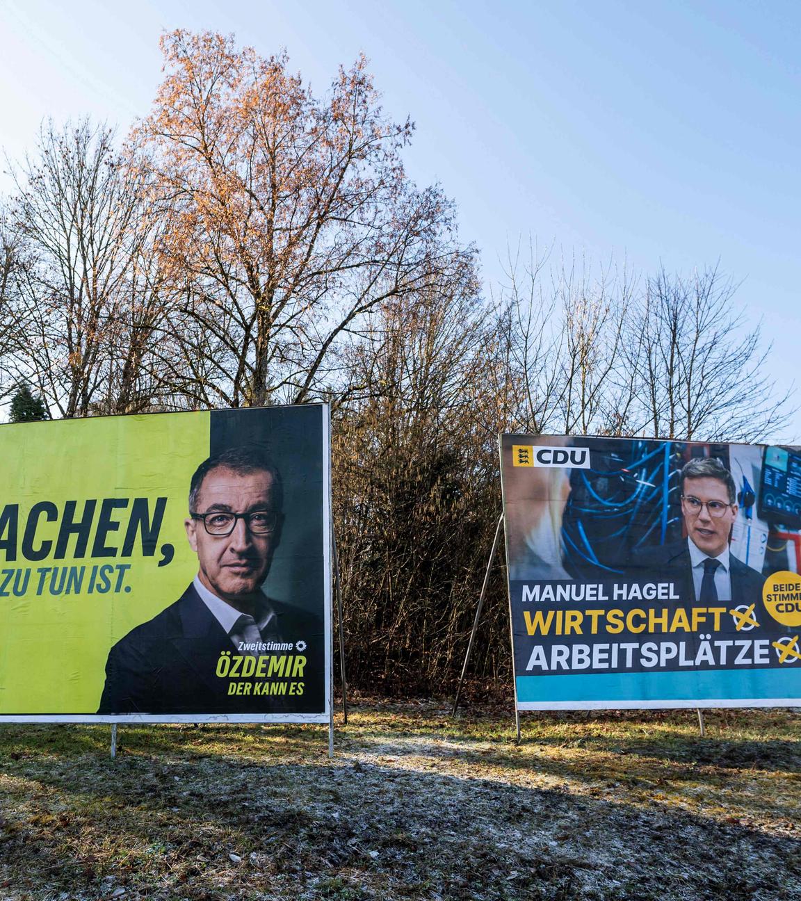 Wahlplakate der Grünen mit Spitzenkandidat Cem Özdemir neben CDU-Plakaten mit Manuel Hagel an einer Straße in Villingen-Schwenningen vor der Landtagswahl in Baden-Württemberg.