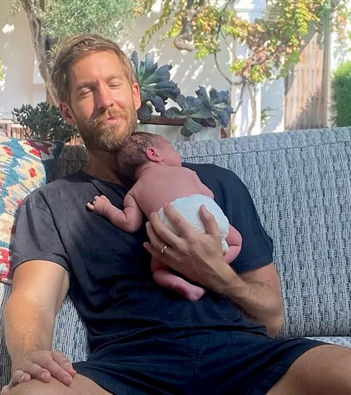 Calvin Harris hält sein Baby im Arm.