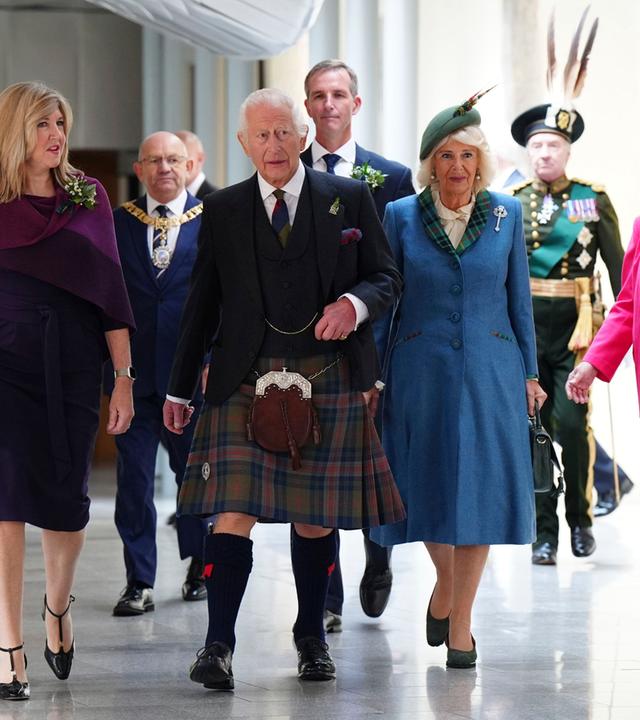 Camilla und Charles laufen im schottischen Parlament mit der Vorsitzenden Alison Johnson einen Gang entlang