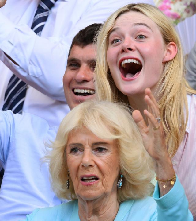 Die britische Königin Camilla ist jubelnd zu sehen, hinter ihr ist Elle Fanning ebenfalls jubelnd zu sehen.