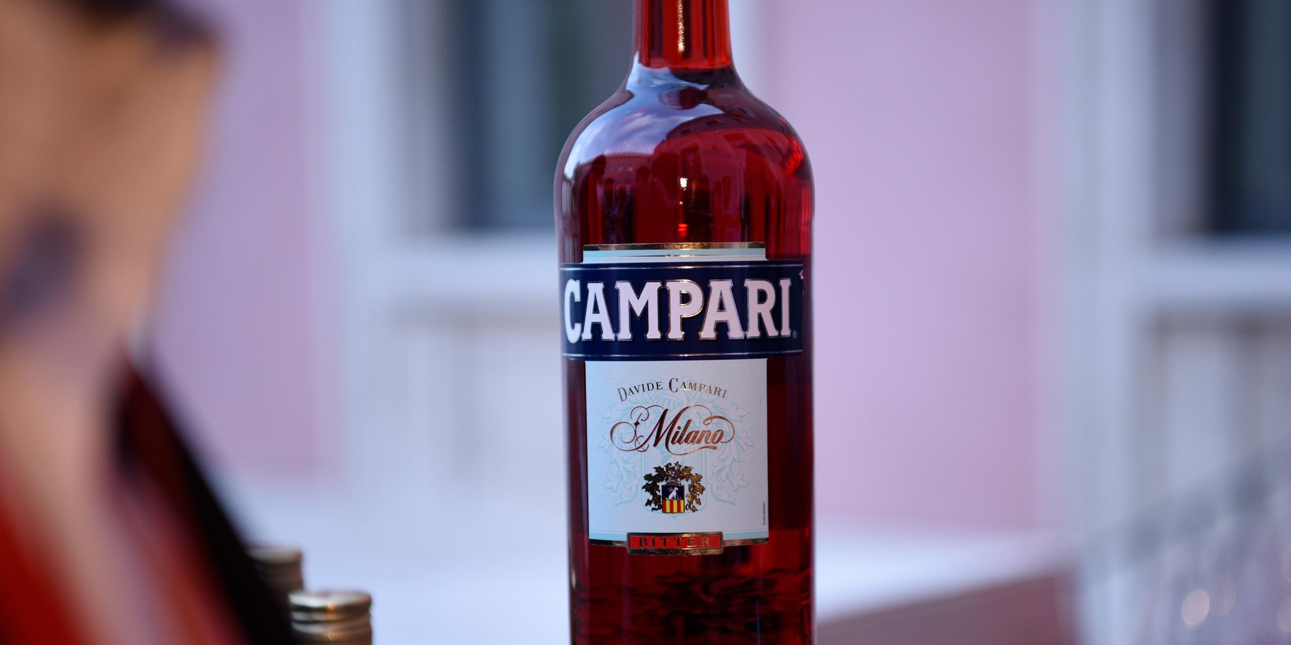 Flaschen des bitteren alkoholischen Likörs Campari, der als Aperitif gilt und aus der Infusion von Kräutern und Früchten in Alkohol und Wasser hergestellt wird.