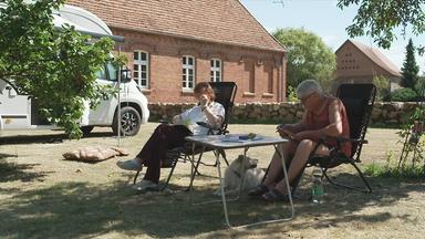 Zwei Camper, die an der Feldsteinkirche in Blüthen campen