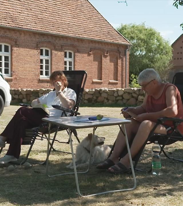 Zwei Camper, die an der Feldsteinkirche in Blüthen campen