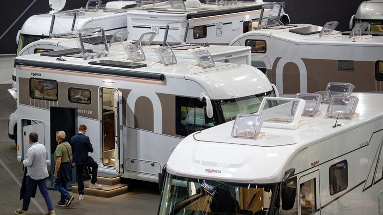 Nordrhein-Westfalen, Düsseldorf: Besucher gehen beim "Caravan Salon - Messe für Caravaning, Camping und Outdoor-Tourismus" durch Hallen mit Campingmobilen.