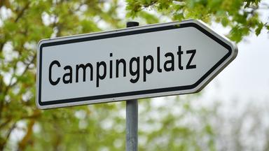 Ein Schild mit der Aufschrift "Campingplatz" als Wegweiser