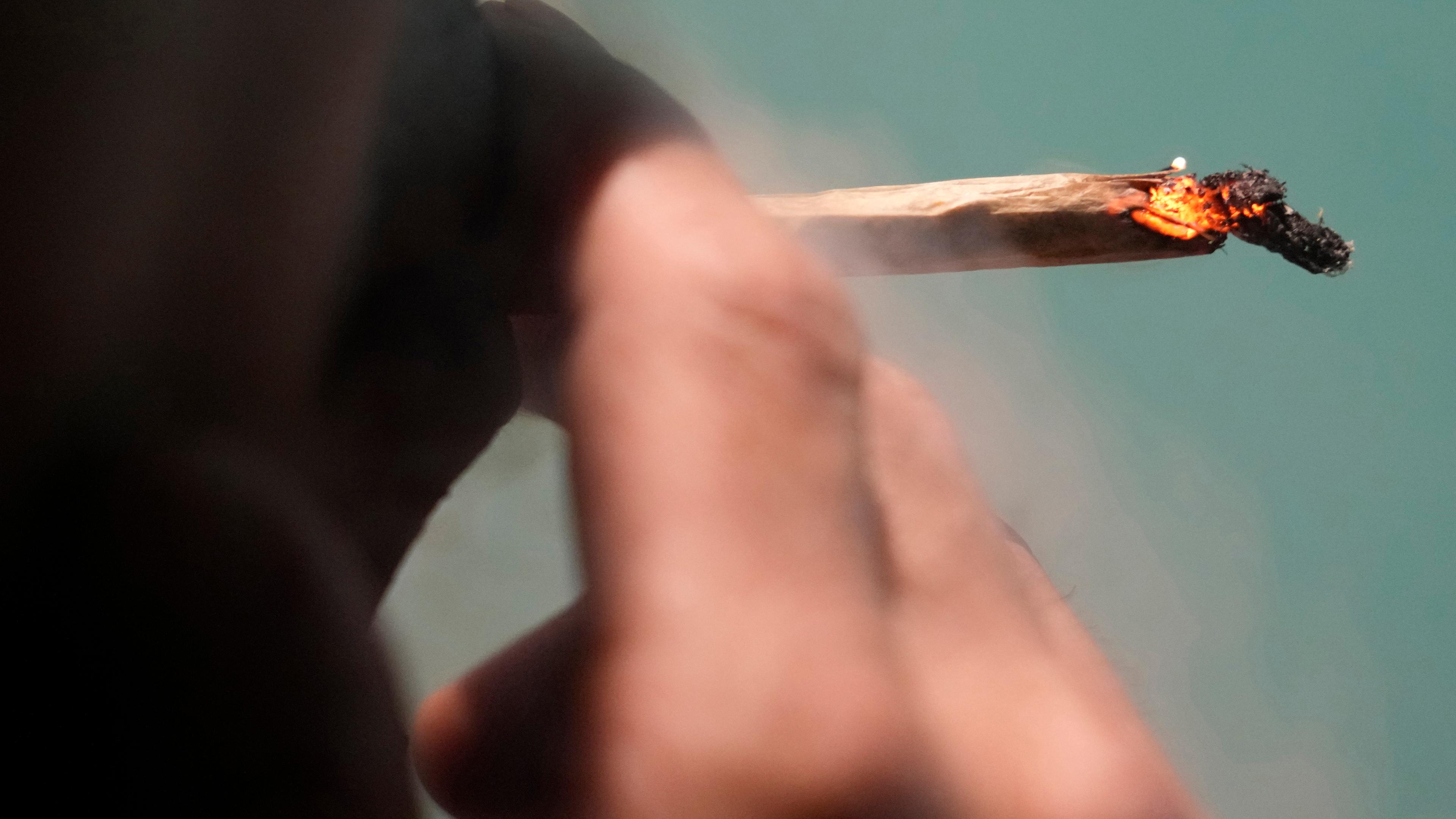 Eine Person raucht eine Cannabis-Zigarette