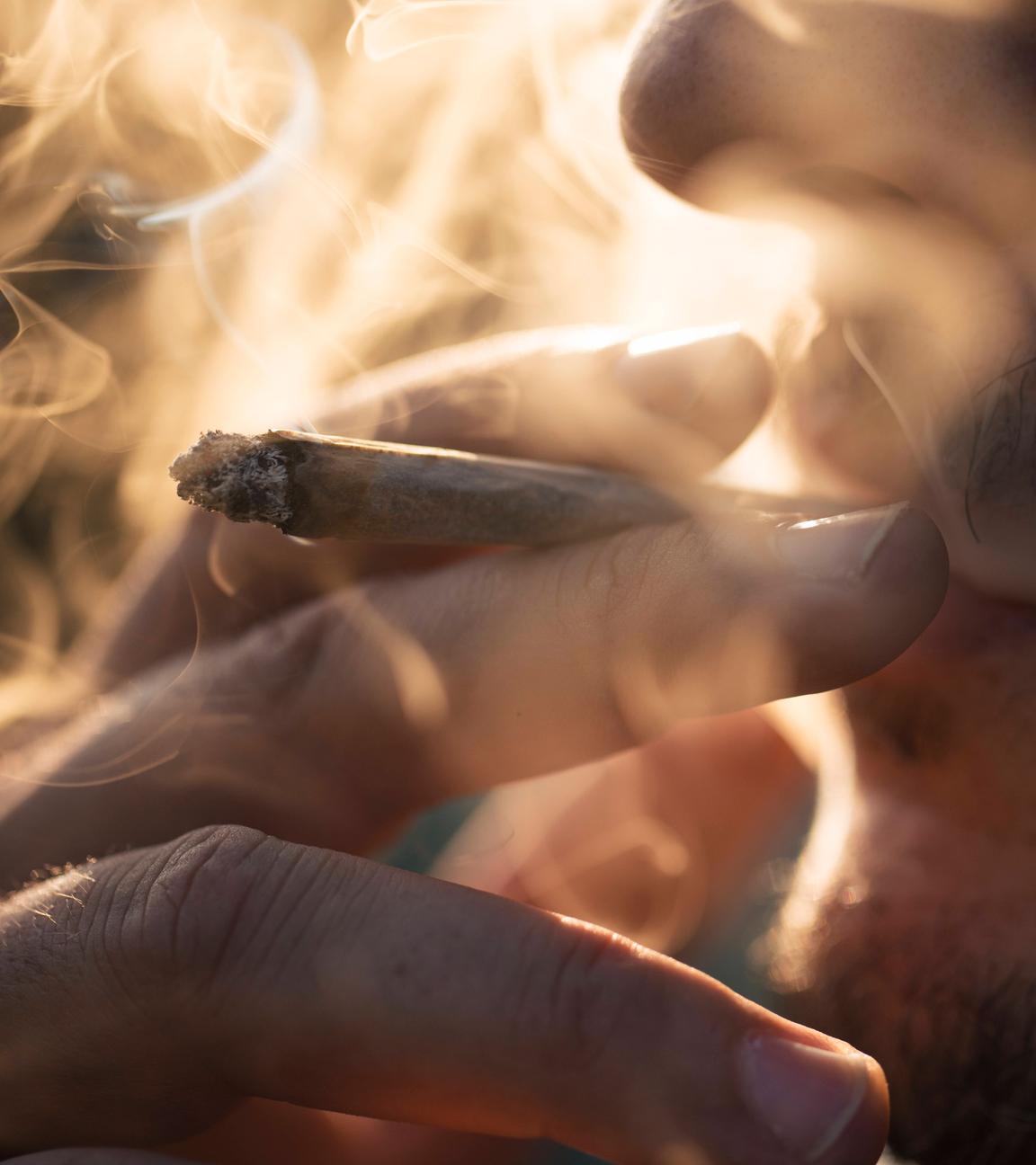 Ein Mann raucht einen Joint.