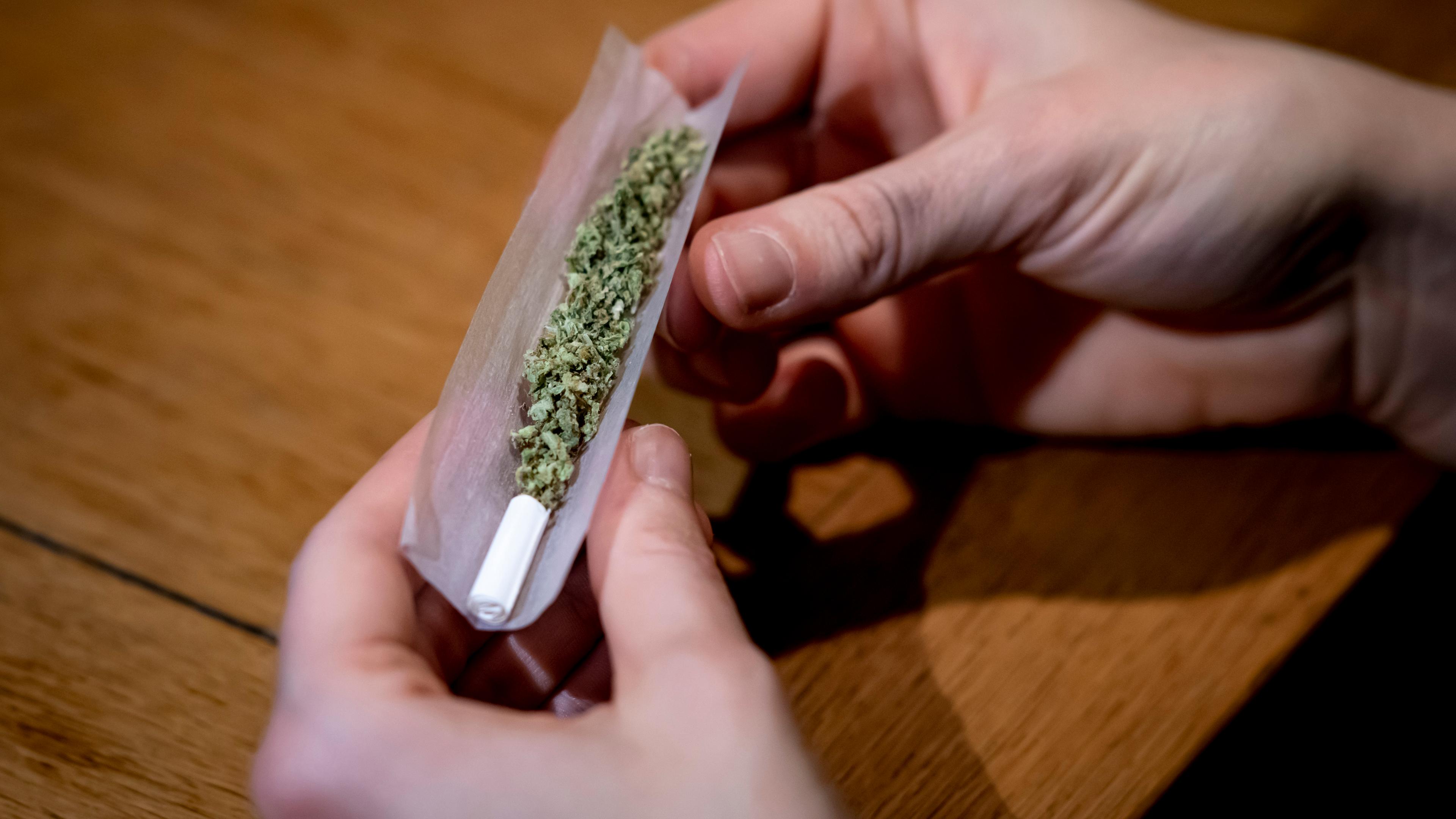 Eine Person dreht sich einen Joint. 