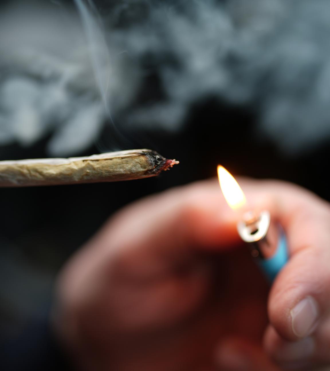 Mann zündet sich Cannabis-Zigarette an