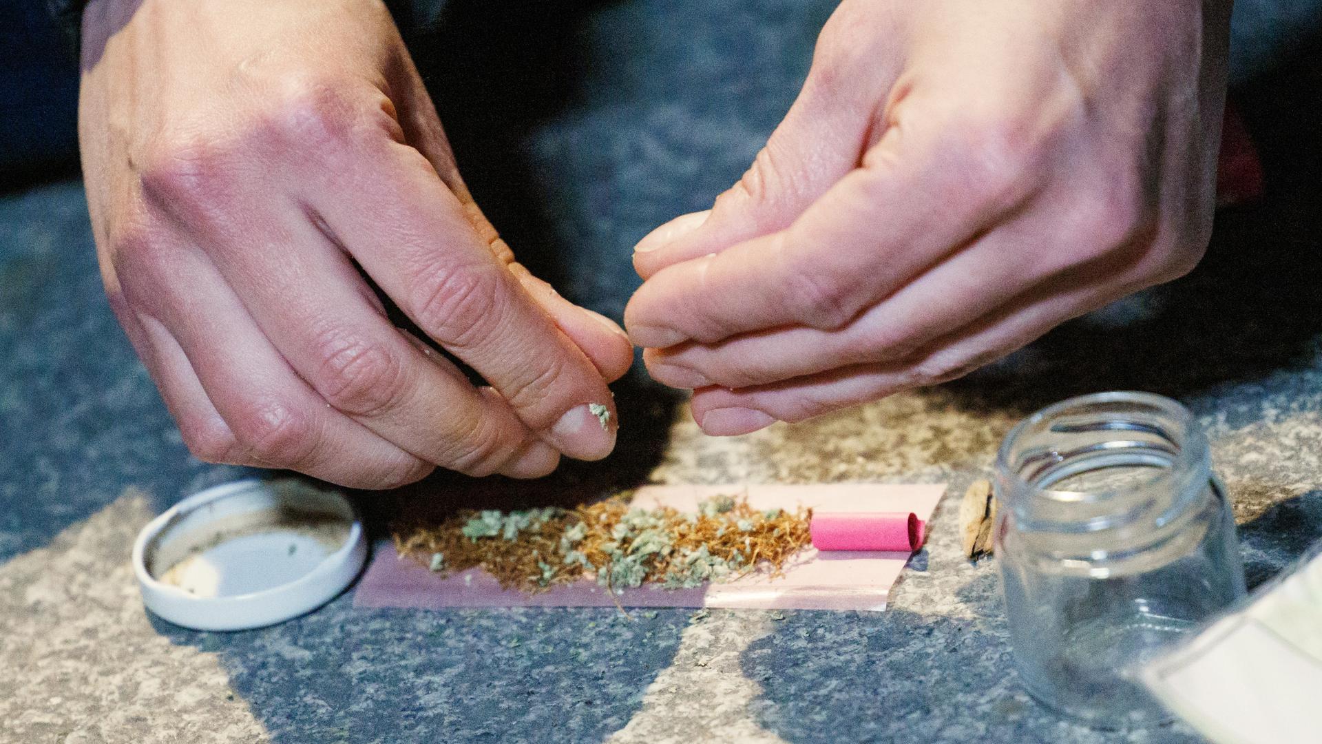 Konsument dreht sich einen Cannabis-Joint.
