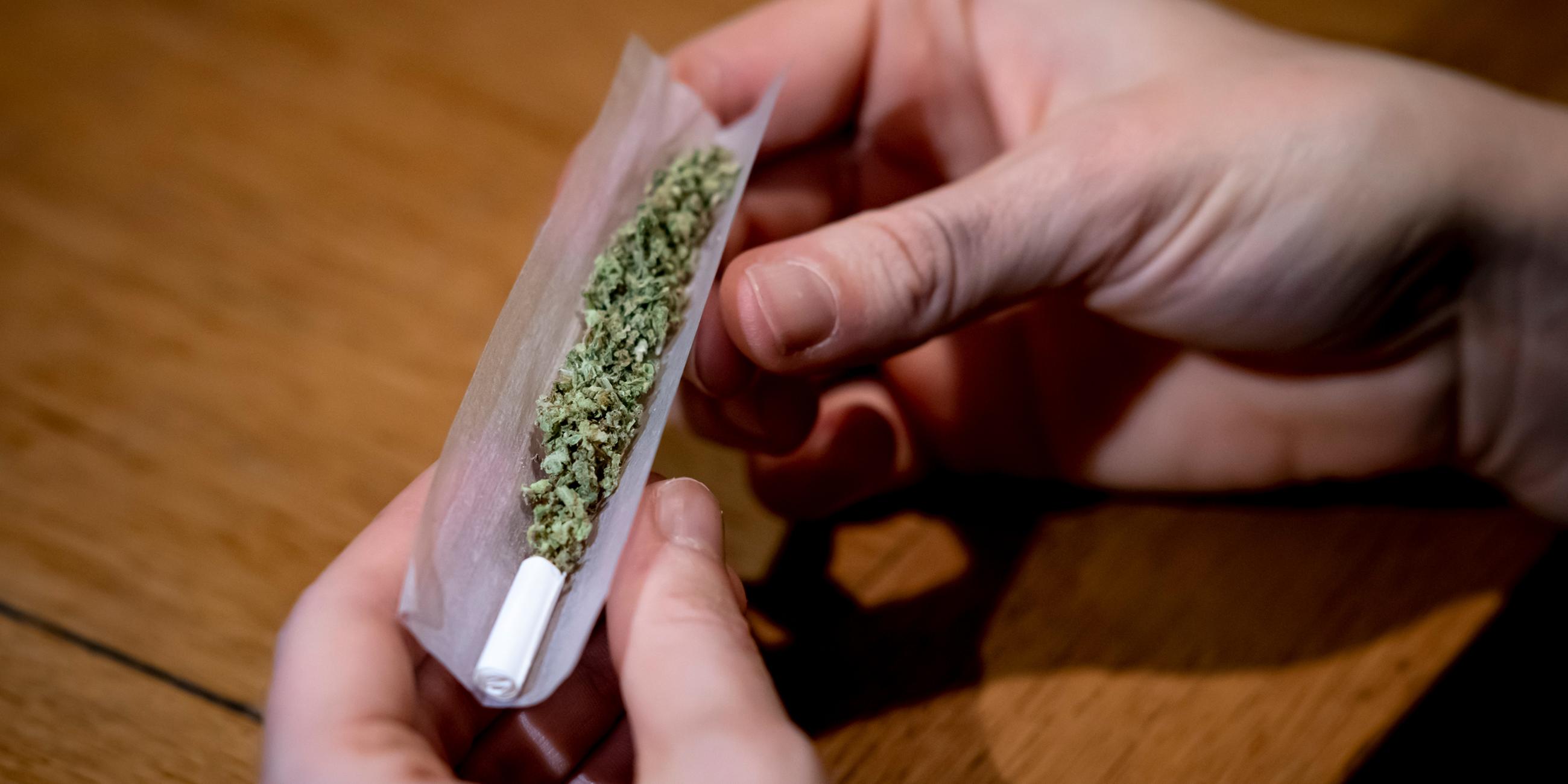 Eine Person dreht sich einen Joint.