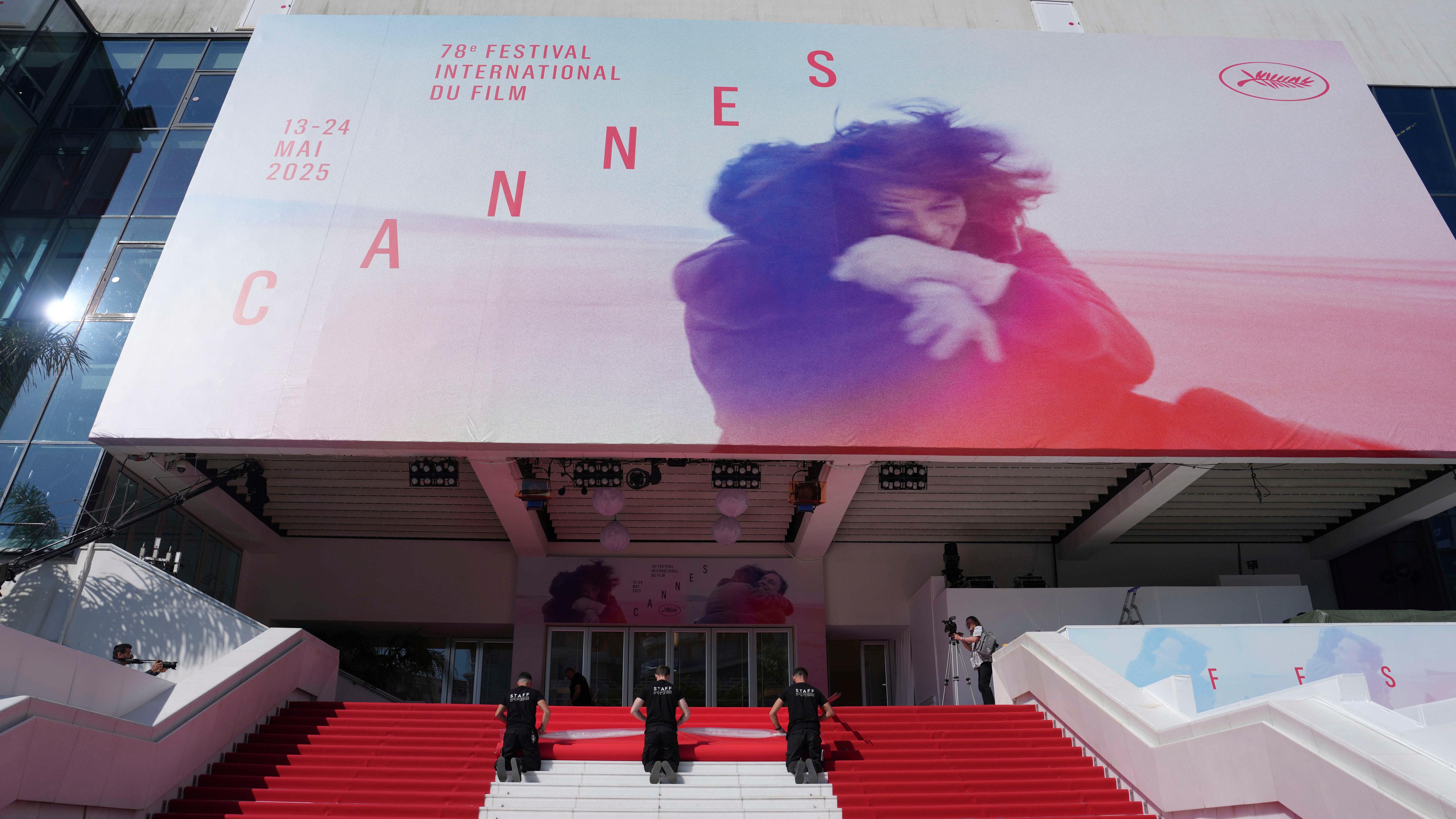 Crewmitglieder verlegen den roten Teppich im Palais des Festivals vor der Eröffnungszeremonie der 78. Internationalen Filmfestspiele in Cannes.