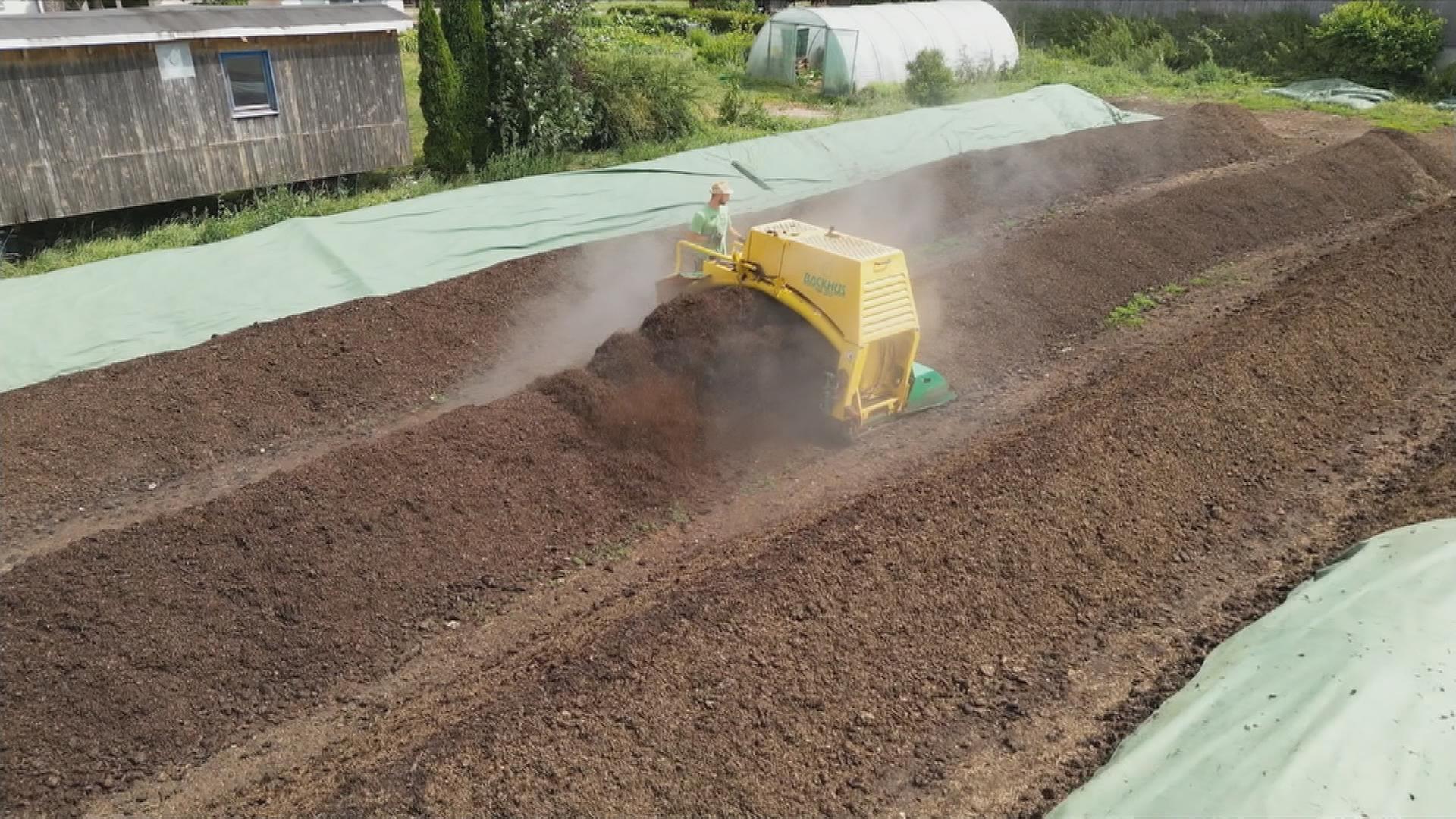 Auf dem Bild ist ein Landwirt bei der Arbeit auf seinem Feld zu sehen.