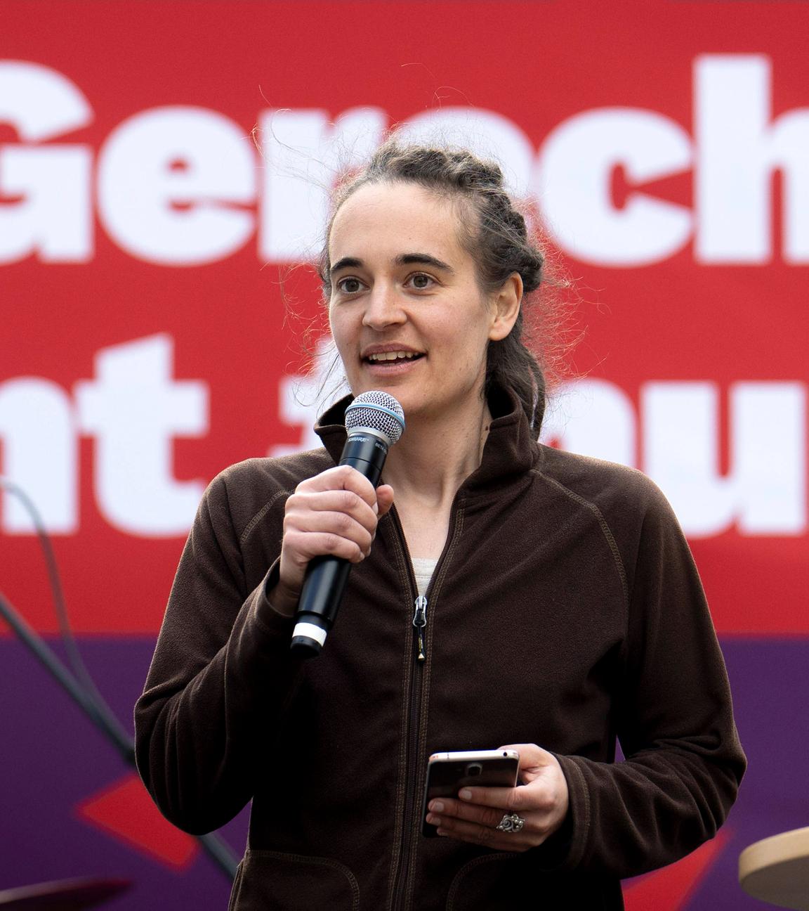 Archivbild: Carola Rackete mit Mikrophon vor Wahlplakat der Linken zur Europawahl in Berlin