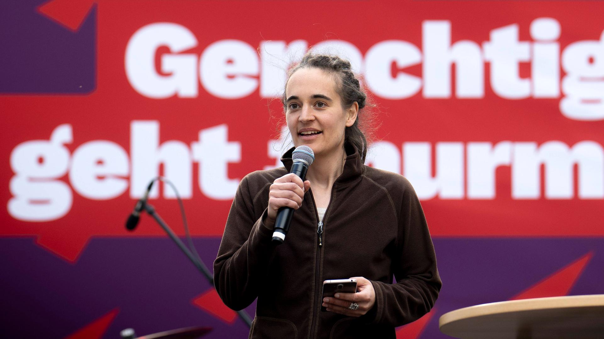 Archivbild: Carola Rackete mit Mikrophon vor Wahlplakat der Linken zur Europawahl in Berlin