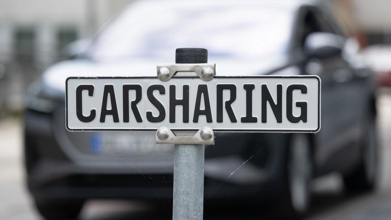 Ein weißes Schild auf einem Parkplatz mit der Aufschrift "Carsharing".