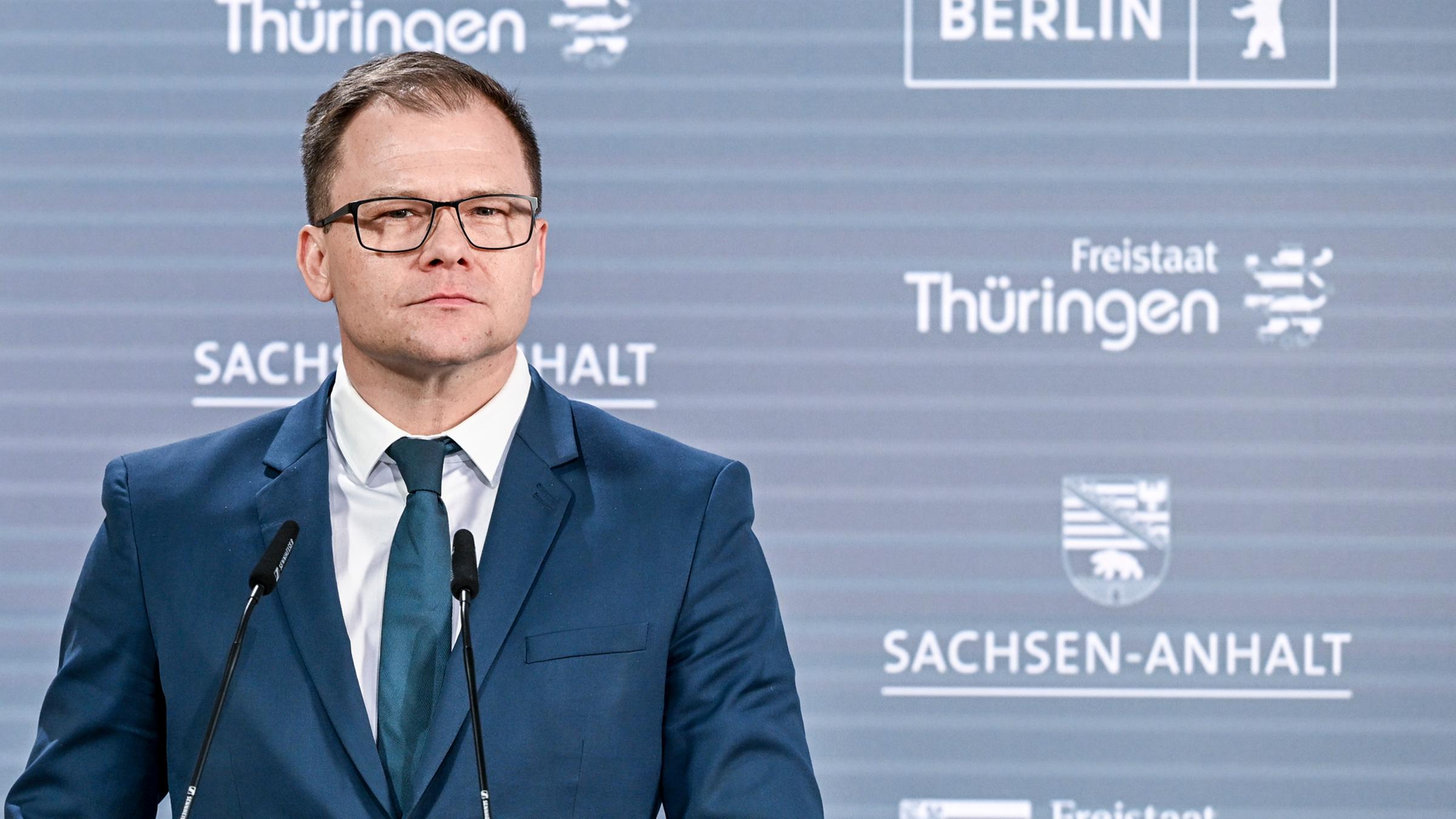 Carsten Schneider steht an einem Rednerpult und schaut in die Ferne.