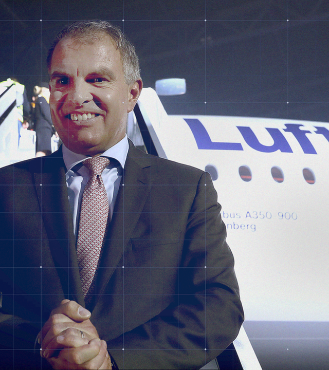 Carsten Spohr steht lächend vor der Gangway einer Lufthansa-Maschine