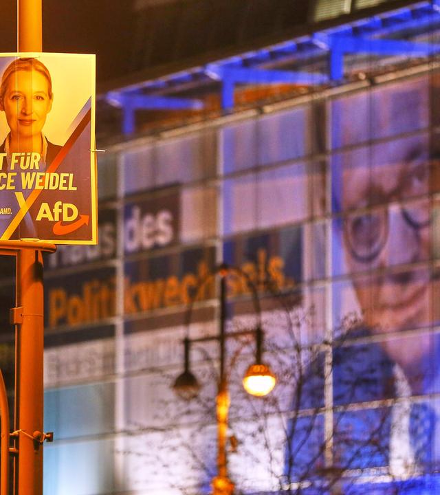 AfD-Wahlplakat mit Alice Weidel fuer die Bundestagswahl, im Hintergrund ein Werbebanner an der CDU-Zentrale mit dem Bild von Friedrich Merz.
